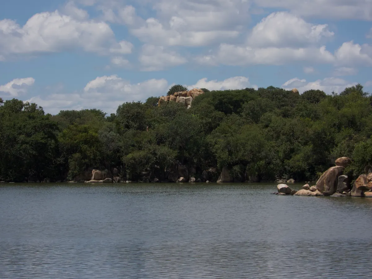 View across a Khami dam to trees on the far bank