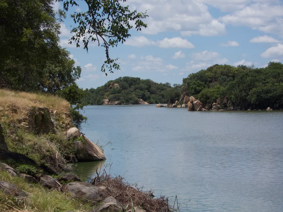 A dam at Khami in the green season, trees in full leaf