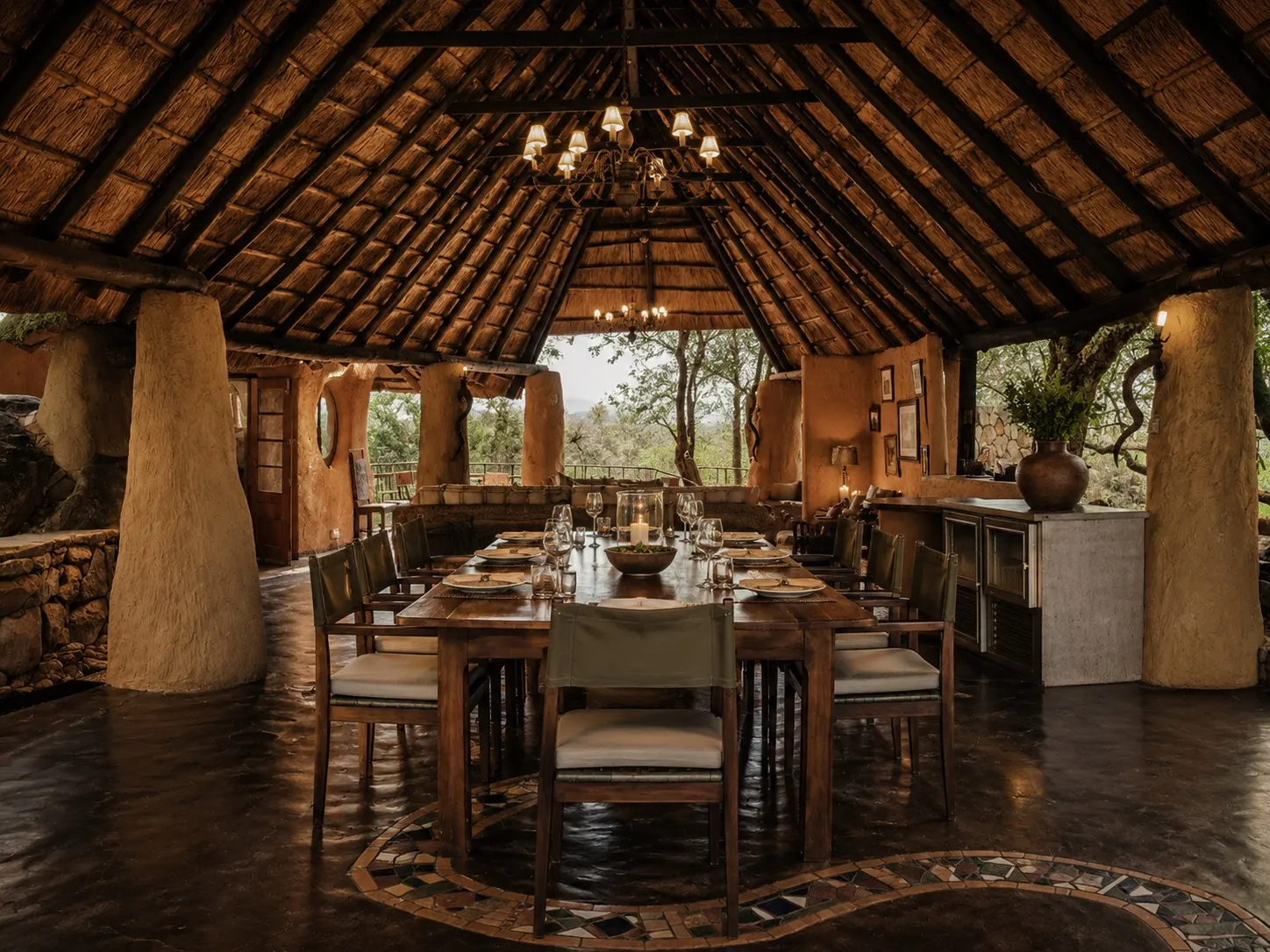 The dining room at Khami Lodge set for dinner beneath the thatch