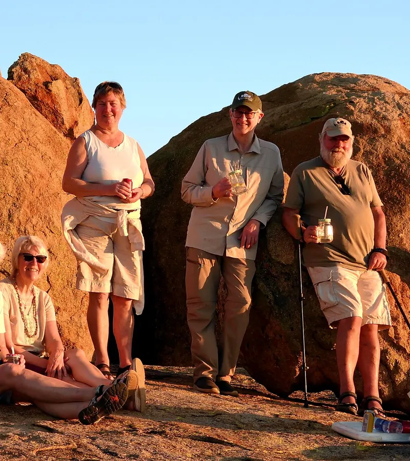 Guests on a granite outcrop at sunset on the Khami reserve