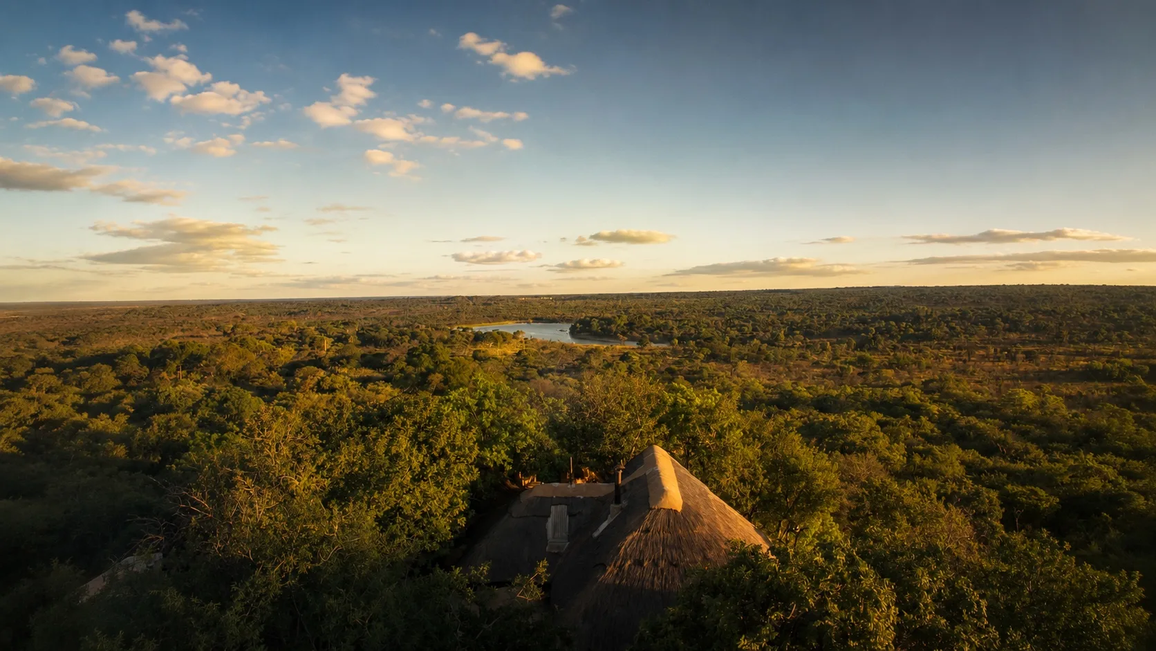 Khami Lodge at dusk from the air, the dam catching the last light