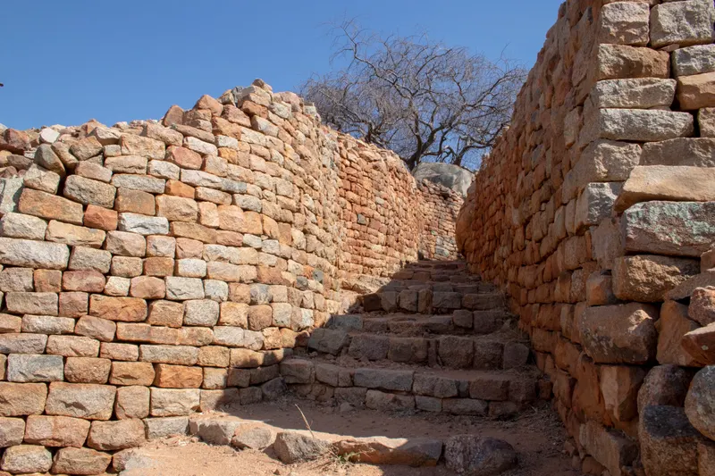 A narrow stone passage between the walls, steps leading up