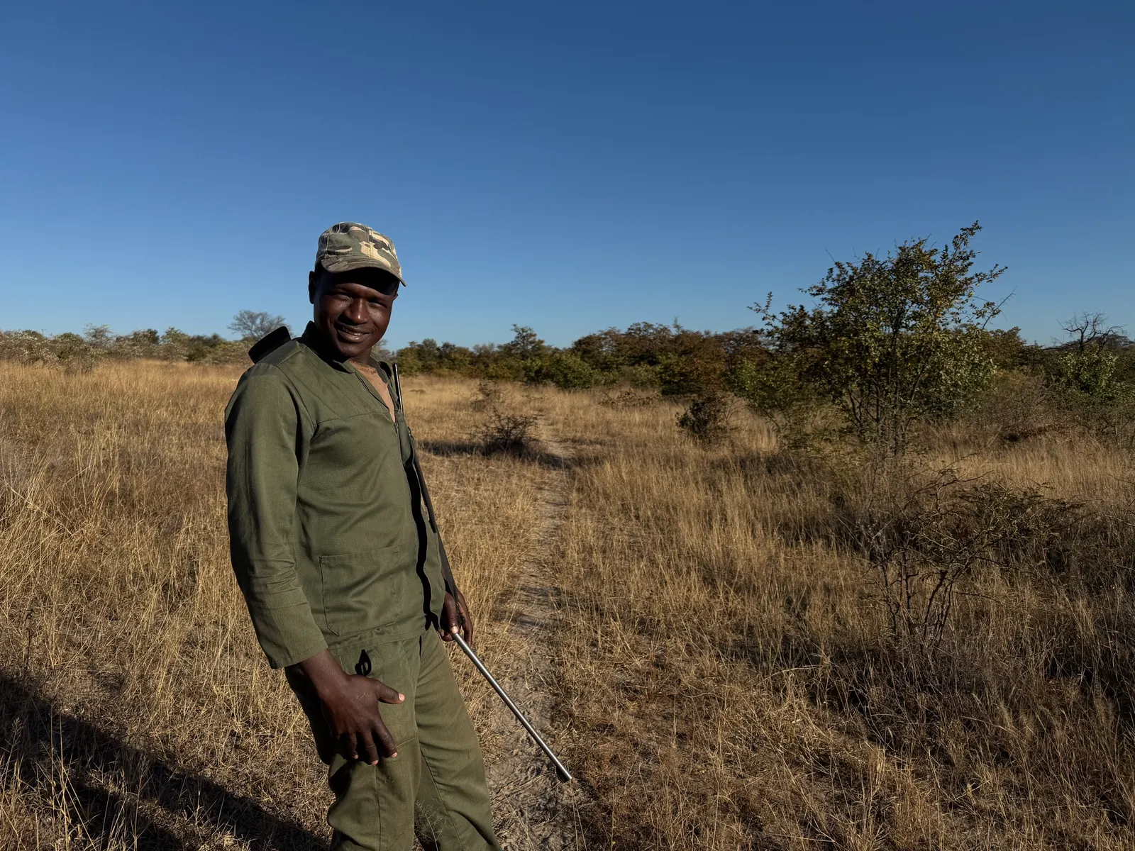 A Khami scout in uniform standing in long grass on the reserve