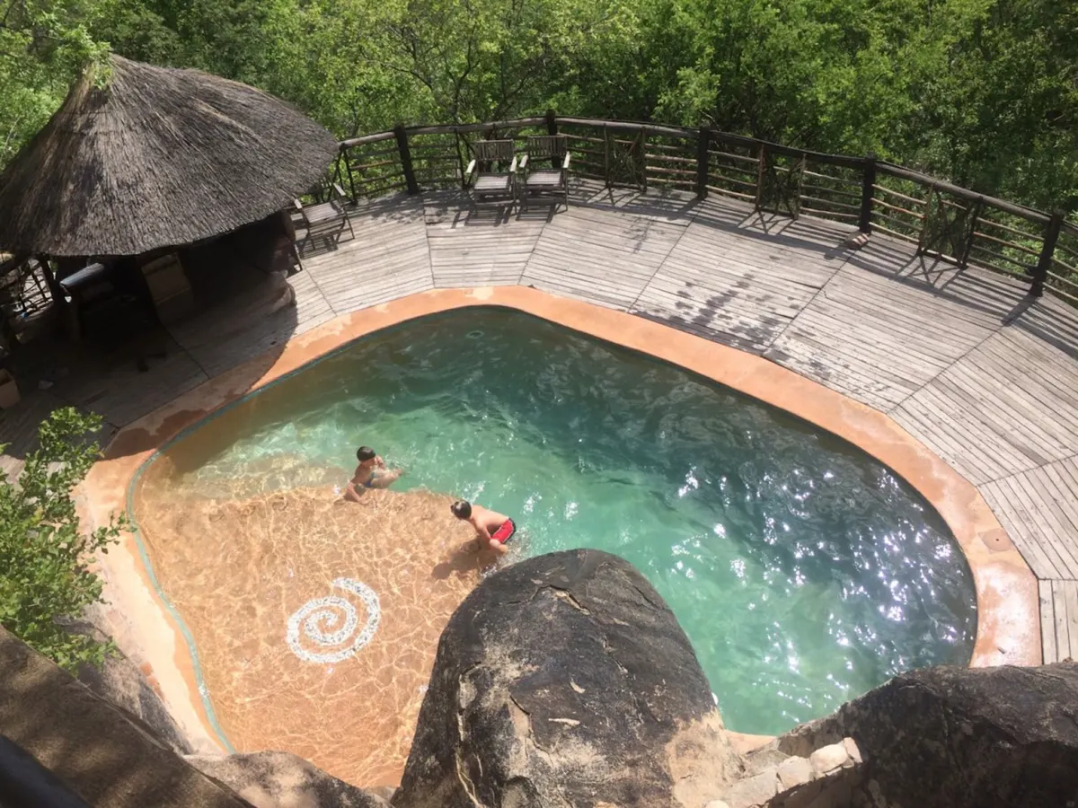 Guests swimming in the pool set into the granite