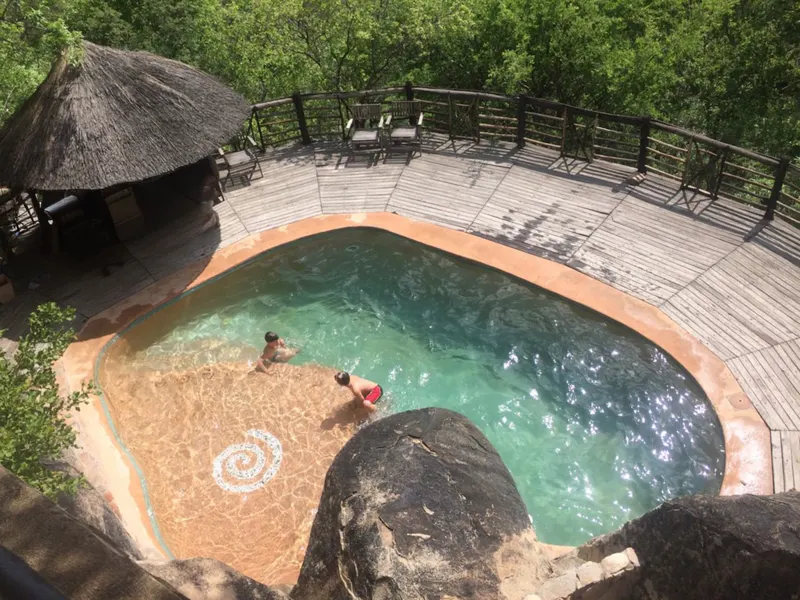 Guests swimming in the pool set into the granite
